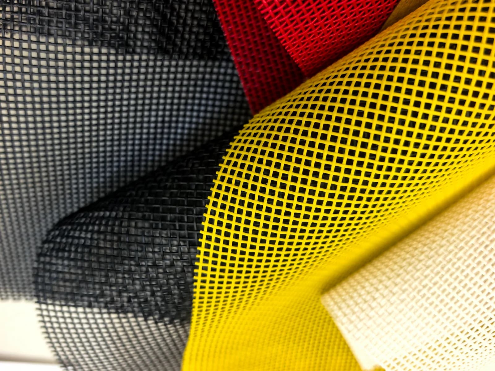 Black, red, yellow and white truck cover mesh rolls